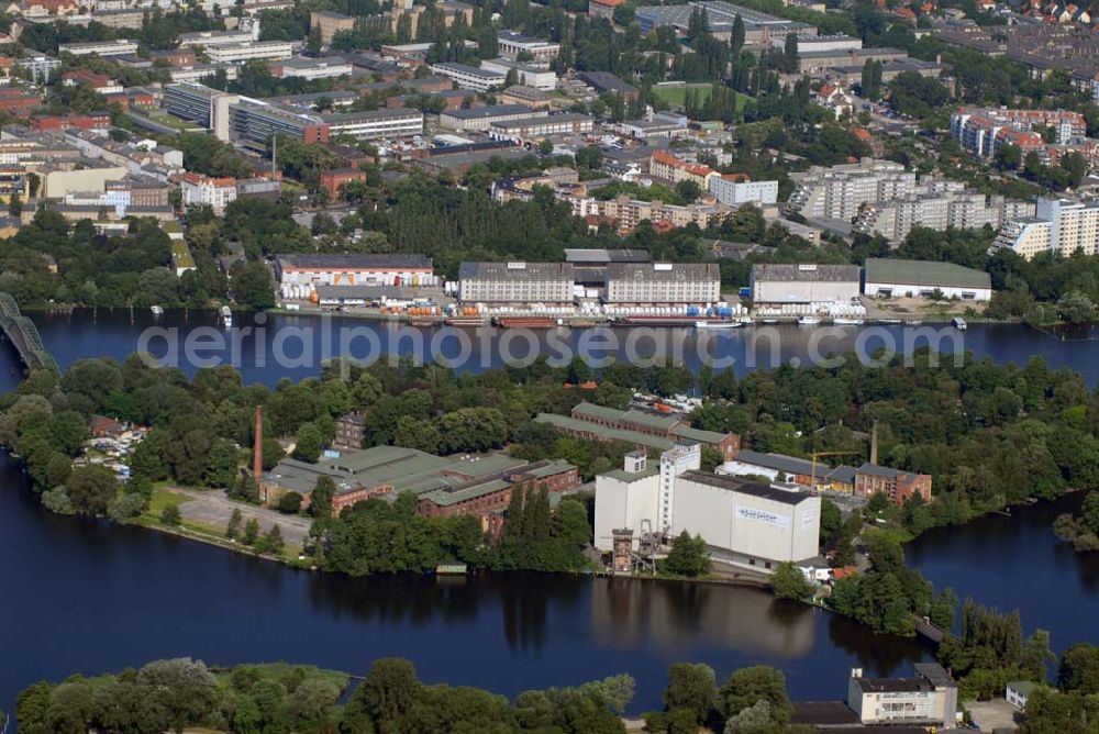 Aerial image Berlin-Spandau - Blick auf die Insel Eiswerder. Die 140.000 m² große Insel liegt inmitten der hier zum Spandauer See erweiterten Havel. Etwa die Hälfte der Insel ist bewaldet. Die im südlichen Teil der Insel befindlichen Gebäude folgen nicht der Bauflucht der Spandauer Uferbebauung, sondern um 45° hierzu gedreht der Achse der Zitadelle.Nach dem Zweiten Weltkrieg dienten die verbliebenen Hallen und Flächen auf dem Eiswerder als Lagerungs- und Umschlagplatz für Getreide, auf dem Salzhof hingegen wurden Tanklager errichtet. Von 1953 bis 1990 lagerte hier der Berliner Senat die erweiterten Senatsreserven. Die Rhenus AG & Co. KG errichtete auf der Insel einen Lokschuppen und eine Wartungsgrube und übernahm 1988 von hier aus die Betriebsführung der Siemens-Güterbahn. Der Eiswerder wurde auch zum Standort verschiedener Bootsclubs