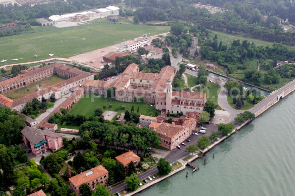 Venedig from the bird's eye view: Blick auf die Insel Lido, einen schmalen Landstreifen, der die Lagune von Venedig von der offenen Adria trennt. Im Zentrum der Insel ist das Benediktinerkloster San Nicolò aus dem 11. Jahrhundert zu erkennen. Dahinter liegt der Flugplatz San Nicolò. View to the island Lido, an small land stripe, wich seperate the lagoon of Venice from the open Adria. In the center of the island is the Benedictine abbey San Nicolò recognizable, wich was built in the 11. century. Behind the abbey, the airport San Nicolò is situated.