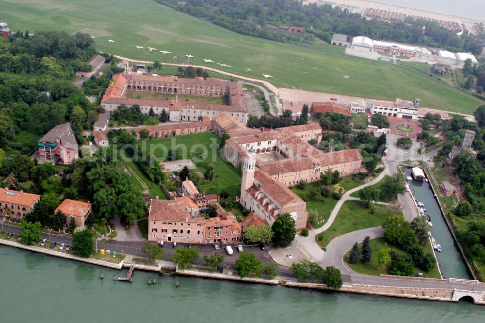 Venedig from the bird's eye view: Blick auf die Insel Lido, einen schmalen Landstreifen, der die Lagune von Venedig von der offenen Adria trennt. Im Zentrum der Insel ist das Benediktinerkloster San Nicolò aus dem 11. Jahrhundert zu erkennen. Dahinter liegt der Flugplatz San Nicolò. View to the island Lido, an small land stripe, wich seperate the lagoon of Venice from the open Adria. In the center of the island is the Benedictine abbey San Nicolò recognizable, wich was built in the 11. century. Behind the abbey, the airport San Nicolò is situated.