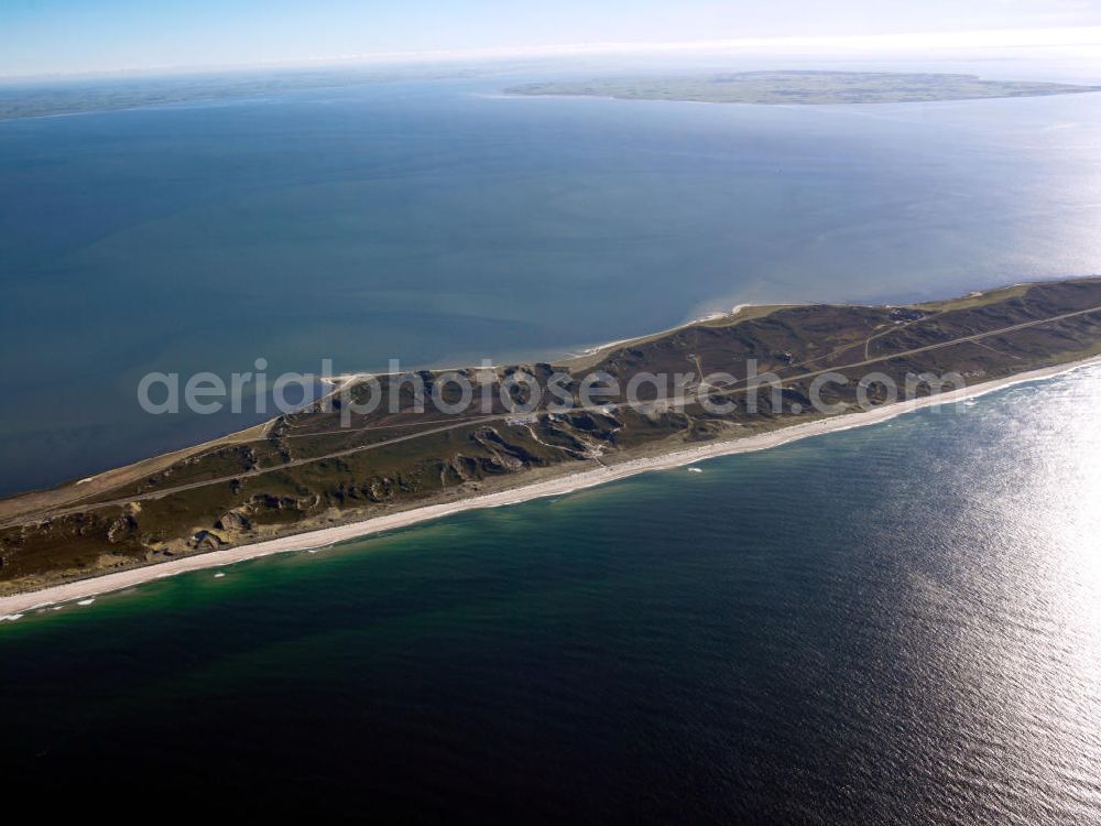 Hörnum ( Sylt ) from above - Blick auf die Insel Sylt. Sylt (dänisch Sild, friesisch Söl) ist die größte nordfriesische Insel. Sie erstreckt sich in Nord-Süd-Richtung vor der Nordseeküste Schleswig-Holsteins. Bekannt ist die nördlichste deutsche Insel vor allem für ihre touristisch bedeutenden Kurorte Westerland, Kampen und Wenningstedt sowie für den knapp 40 Kilometer langen Weststrand. Wegen ihrer exponierten Lage in der Nordsee kommt es zu kontinuierlichen Landverlusten bei Sturmfluten. Seit 1927 ist Sylt über den Hindenburgdamm mit dem Festland verbunden. Island of Sylt. Sylt is the largest North Frisian island of Schleswig-Holstein