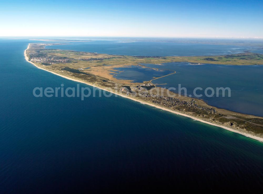 Hörnum ( Sylt ) from the bird's eye view: Blick auf die Insel Sylt. Sylt (dänisch Sild, friesisch Söl) ist die größte nordfriesische Insel. Sie erstreckt sich in Nord-Süd-Richtung vor der Nordseeküste Schleswig-Holsteins. Bekannt ist die nördlichste deutsche Insel vor allem für ihre touristisch bedeutenden Kurorte Westerland, Kampen und Wenningstedt sowie für den knapp 40 Kilometer langen Weststrand. Wegen ihrer exponierten Lage in der Nordsee kommt es zu kontinuierlichen Landverlusten bei Sturmfluten. Seit 1927 ist Sylt über den Hindenburgdamm mit dem Festland verbunden. Island of Sylt. Sylt is the largest North Frisian island of Schleswig-Holstein