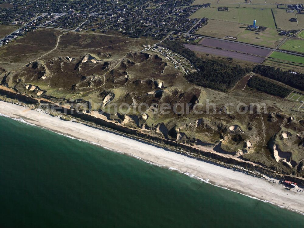 Hörnum (Sylt) from above - Blick auf die Insel Sylt. Sylt (dänisch Sild, friesisch Söl) ist die größte nordfriesische Insel. Sie erstreckt sich in Nord-Süd-Richtung vor der Nordseeküste Schleswig-Holsteins. Bekannt ist die nördlichste deutsche Insel vor allem für ihre touristisch bedeutenden Kurorte Westerland, Kampen und Wenningstedt sowie für den knapp 40 Kilometer langen Weststrand. Wegen ihrer exponierten Lage in der Nordsee kommt es zu kontinuierlichen Landverlusten bei Sturmfluten. Seit 1927 ist Sylt über den Hindenburgdamm mit dem Festland verbunden. Island of Sylt. Sylt is the largest North Frisian island of Schleswig-Holstein