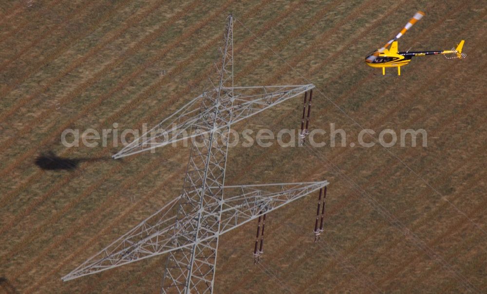 Drensteinfurt from the bird's eye view: Inspection of poles and power lines of a utility by a helicopter flying low at Drensteinfurt in North Rhine-Westphalia