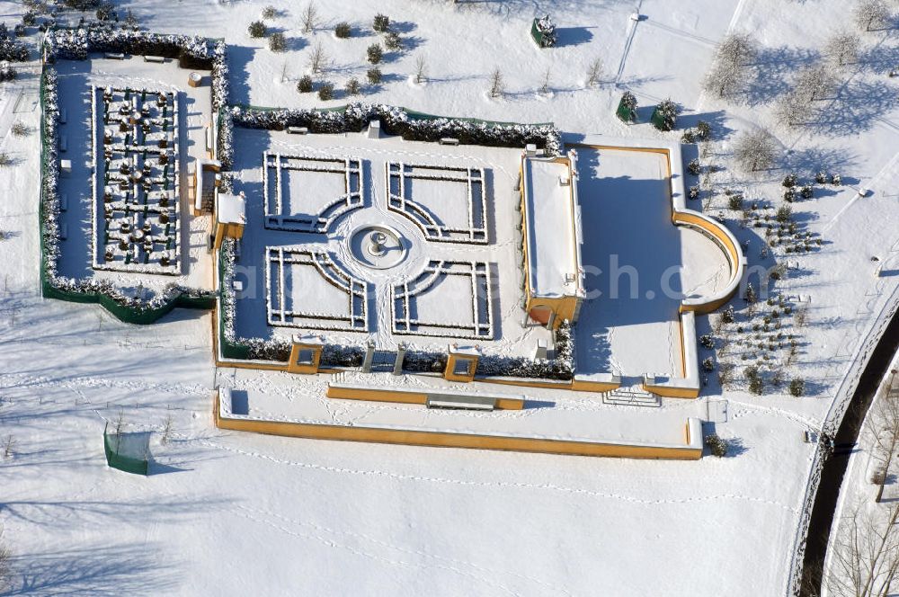 Aerial photograph Berlin - Blick auf den Italienischen Garten im winterlich verschneiten Chinesischen Garten im Erholungspark Marzahn. Der Erholungspark Marzahn liegt im Berliner Bezirk Marzahn-Hellersdorf am nördlichen Fuß des Kienbergs und wurde am 9. Mai 1987 anlässlich der 750-Jahr-Feier von Berlin als Berliner Gartenschau und Geschenk der Gärtner an die Hauptstadt der DDR (Ost-Berlin) eröffnet und sollte somit ein Gegenstück zum Britzer Garten im damaligen West-Berlin darstellen. 1991 wurde die Berliner Gartenschau nicht nur in Erholungspark Marzahn umbenannt, sondern auch umgebaut: Große Spiel- und Liegewiesen sowie neue Spielplätze entstanden, Bäume wurden gepflanzt und Sondergärten überarbeitet und erweitert. Der neu gestaltete Park sollte den 300.000 Bewohnern der umliegenden Großsiedlungen als vielfältig nutzbare Erholungslandschaft dienen. Seit Oktober 2000 ist diese durch ihre Gärten der Welt auch weit über die Stadtgrenzen hinaus bekannt. 2005 wurde der Chinesische Garten im Erholungspark Marzahn als drittschönste Parkanlage Deutschlands ausgezeichnet. Außerdem gehört der Erholungspark zu den 365 Orten im Land der Ideen.