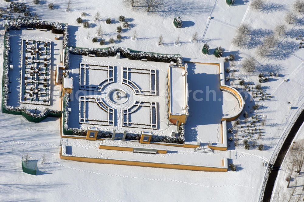 Berlin from above - Blick auf den Italienischen Garten im winterlich verschneiten Chinesischen Garten im Erholungspark Marzahn. Der Erholungspark Marzahn liegt im Berliner Bezirk Marzahn-Hellersdorf am nördlichen Fuß des Kienbergs und wurde am 9. Mai 1987 anlässlich der 750-Jahr-Feier von Berlin als Berliner Gartenschau und Geschenk der Gärtner an die Hauptstadt der DDR (Ost-Berlin) eröffnet und sollte somit ein Gegenstück zum Britzer Garten im damaligen West-Berlin darstellen. 1991 wurde die Berliner Gartenschau nicht nur in Erholungspark Marzahn umbenannt, sondern auch umgebaut: Große Spiel- und Liegewiesen sowie neue Spielplätze entstanden, Bäume wurden gepflanzt und Sondergärten überarbeitet und erweitert. Der neu gestaltete Park sollte den 300.000 Bewohnern der umliegenden Großsiedlungen als vielfältig nutzbare Erholungslandschaft dienen. Seit Oktober 2000 ist diese durch ihre Gärten der Welt auch weit über die Stadtgrenzen hinaus bekannt. 2005 wurde der Chinesische Garten im Erholungspark Marzahn als drittschönste Parkanlage Deutschlands ausgezeichnet. Außerdem gehört der Erholungspark zu den 365 Orten im Land der Ideen.