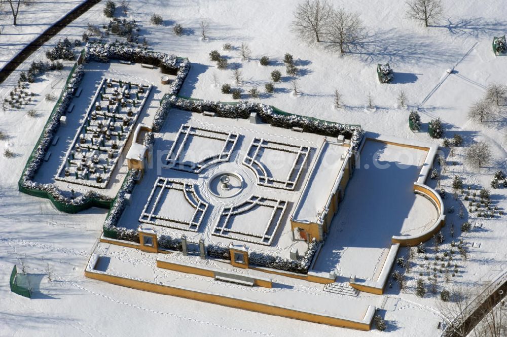 Berlin from the bird's eye view: Blick auf den Italienischen Garten im winterlich verschneiten Chinesischen Garten im Erholungspark Marzahn. Der Erholungspark Marzahn liegt im Berliner Bezirk Marzahn-Hellersdorf am nördlichen Fuß des Kienbergs und wurde am 9. Mai 1987 anlässlich der 750-Jahr-Feier von Berlin als Berliner Gartenschau und Geschenk der Gärtner an die Hauptstadt der DDR (Ost-Berlin) eröffnet und sollte somit ein Gegenstück zum Britzer Garten im damaligen West-Berlin darstellen. 1991 wurde die Berliner Gartenschau nicht nur in Erholungspark Marzahn umbenannt, sondern auch umgebaut: Große Spiel- und Liegewiesen sowie neue Spielplätze entstanden, Bäume wurden gepflanzt und Sondergärten überarbeitet und erweitert. Der neu gestaltete Park sollte den 300.000 Bewohnern der umliegenden Großsiedlungen als vielfältig nutzbare Erholungslandschaft dienen. Seit Oktober 2000 ist diese durch ihre Gärten der Welt auch weit über die Stadtgrenzen hinaus bekannt. 2005 wurde der Chinesische Garten im Erholungspark Marzahn als drittschönste Parkanlage Deutschlands ausgezeichnet. Außerdem gehört der Erholungspark zu den 365 Orten im Land der Ideen.