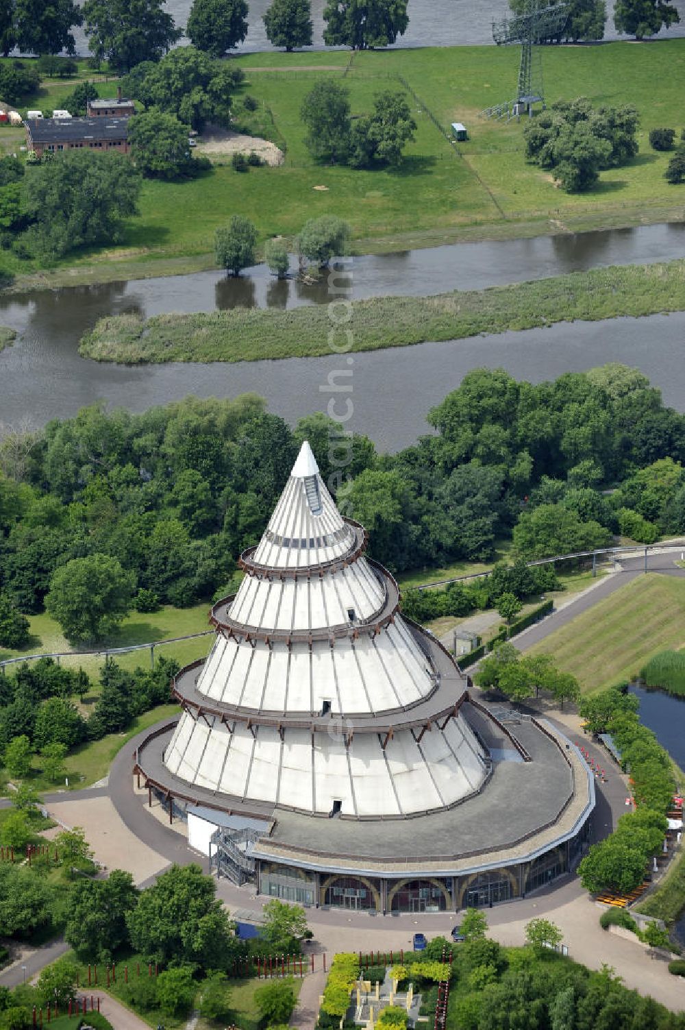 Magdeburg from the bird's eye view: Blick auf den Jahrtausendturm im Elbauenpark, auch als die BUGA - Pyramide bekannt. Der Jahrtausendturm in Magdeburg ist mit 60 Metern Höhe das höchste Holzgebäude Deutschlands und wurde anlässlich der Bundesgartenschau 1999 errichtet. Betreiber ist die Messe- und Veranstaltungsgesellschaft Magdeburg GmbH. View of the Millennium Tower in Elbauenpark. The Millennium Tower in Magdeburg is 60 meters is the tallest wooden building in Germany and was built at the Federal Garden Show 1999th