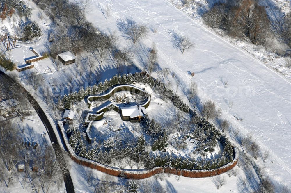 Berlin from above - Blick auf den Japanischen Garten im winterlich verschneiten Chinesischen Garten im Erholungspark Marzahn. Der Erholungspark Marzahn liegt im Berliner Bezirk Marzahn-Hellersdorf am nördlichen Fuß des Kienbergs und wurde am 9. Mai 1987 anlässlich der 750-Jahr-Feier von Berlin als Berliner Gartenschau und Geschenk der Gärtner an die Hauptstadt der DDR (Ost-Berlin) eröffnet und sollte somit ein Gegenstück zum Britzer Garten im damaligen West-Berlin darstellen. 1991 wurde die Berliner Gartenschau nicht nur in Erholungspark Marzahn umbenannt, sondern auch umgebaut: Große Spiel- und Liegewiesen sowie neue Spielplätze entstanden, Bäume wurden gepflanzt und Sondergärten überarbeitet und erweitert. Der neu gestaltete Park sollte den 300.000 Bewohnern der umliegenden Großsiedlungen als vielfältig nutzbare Erholungslandschaft dienen. Seit Oktober 2000 ist diese durch ihre Gärten der Welt auch weit über die Stadtgrenzen hinaus bekannt. 2005 wurde der Chinesische Garten im Erholungspark Marzahn als drittschönste Parkanlage Deutschlands ausgezeichnet. Außerdem gehört der Erholungspark zu den 365 Orten im Land der Ideen.