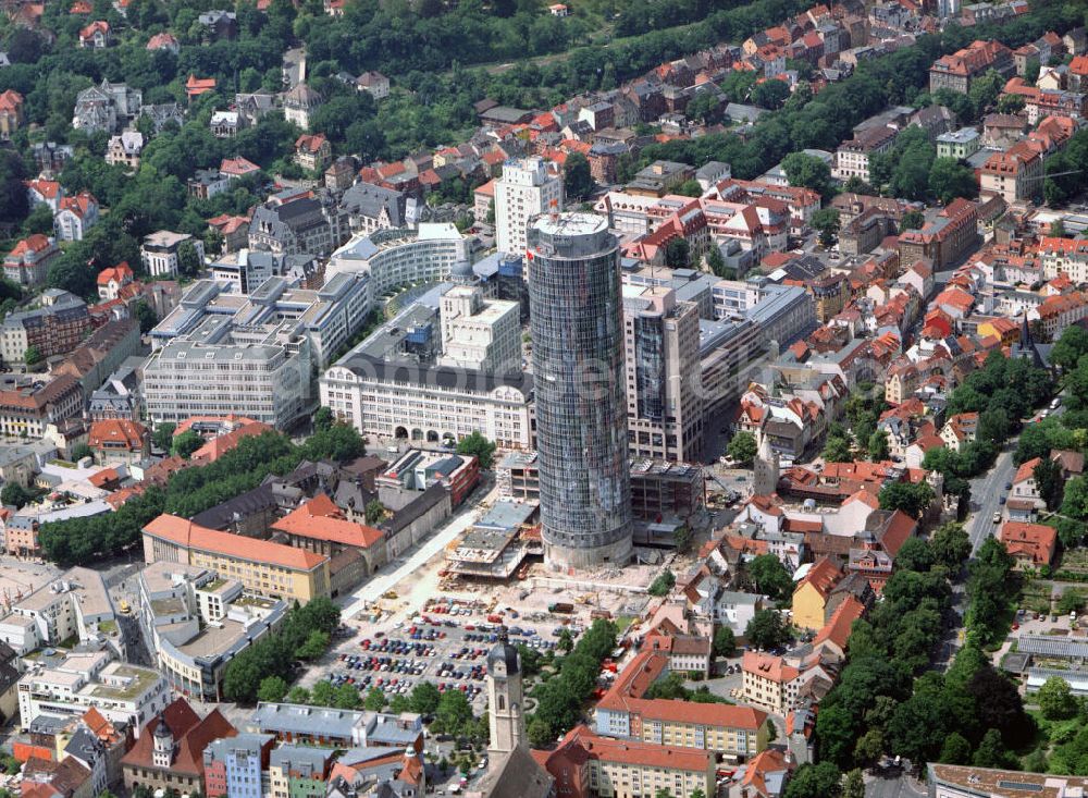 Aerial photograph Jena - Blick auf den JenTower. Der JenTower oder Intershop Tower ist ein Hochhaus in Jena. Es ist mit 133 Metern Höhe (mit Antennenspitze 159,60 m) das zweithöchste Bürogebäude der östlichen Bundesländer nach dem Cityhochhaus in Leipzig. Er verfügt über 31 Geschosse, davon 2 Untergeschosse und 29 Obergeschosse. Der Turm wird heute überwiegend als Bürogebäude genutzt. Hauptmieter ist mit rund der Hälfte der Flächen die Firma Intershop Communications AG, die hier Ihren Firmenhauptsitz hat. Im Umfeld des Unternehmens haben sich weitere Unternehmen aus dem IT-Bereich angesiedelt, die teilweise aus Intershop hervorgegangen sind. Im 28. und 29. Obergeschoss befinden sich ein täglich geöffnetes Restaurant und eine öffentliche Aussichtsplattform. Im 29. Geschoss befinden sich Sendeanlagen mehrerer Mobilfunkbetreiber, die die Antennenanlage des Gebäudes nutzen.