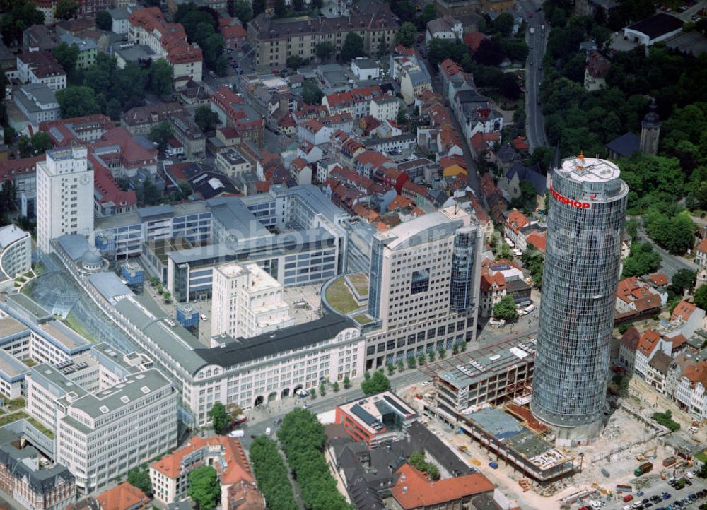 Aerial image Jena - Blick auf den JenTower. Der JenTower oder Intershop Tower ist ein Hochhaus in Jena. Es ist mit 133 Metern Höhe (mit Antennenspitze 159,60 m) das zweithöchste Bürogebäude der östlichen Bundesländer nach dem Cityhochhaus in Leipzig. Er verfügt über 31 Geschosse, davon 2 Untergeschosse und 29 Obergeschosse. Der Turm wird heute überwiegend als Bürogebäude genutzt. Hauptmieter ist mit rund der Hälfte der Flächen die Firma Intershop Communications AG, die hier Ihren Firmenhauptsitz hat. Im Umfeld des Unternehmens haben sich weitere Unternehmen aus dem IT-Bereich angesiedelt, die teilweise aus Intershop hervorgegangen sind. Im 28. und 29. Obergeschoss befinden sich ein täglich geöffnetes Restaurant und eine öffentliche Aussichtsplattform. Im 29. Geschoss befinden sich Sendeanlagen mehrerer Mobilfunkbetreiber, die die Antennenanlage des Gebäudes nutzen.