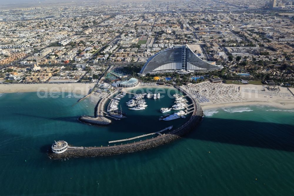 Dubai from above - The Jumeirah beach hotel is landmark and symbol of Dubai in the United Arab Emirates. Directly at the hotel, the port facility for yachts and the beach on the Gulf of Persia