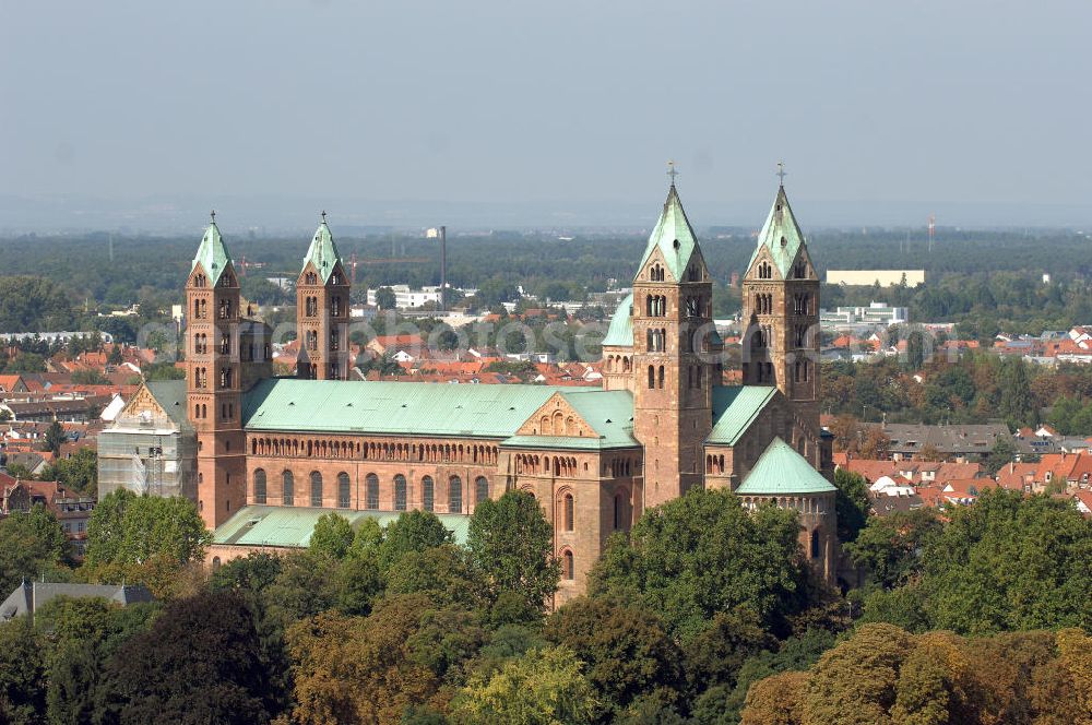 SPEYER from the bird's eye view: Der Kaiser- und Mariendom zu Speyer ist nach der Zerstörung der Abtei Cluny die größte noch erhaltene romanische Kirche der Welt und steht seit 1981 auf der UNESCO-Liste des Weltkulturerbes.Der salische Kaiser Konrad II. gründete um 1030 den Bau mit dem Ziel, die größte Kirche des Abendlandes zu bauen.Knapp 20 Jahre nach der Vollendung von Speyer I ließ Heinrich IV. den Dom zur Hälfte einreißen, um ihn noch größer wieder aufzubauen: Im Mittelschiff wurde die Decke abgetragen, der Bau wurde um fünf Meter erhöht. Statt der flachen Holzdecke entstand das größte Kreuzgratgewölbe im damaligen Reichsgebiet, auch der Wandaufriss erfuhr entscheidende Veränderungen. Im Ostteil wurde der Bau bis auf die Fundamente abgetragen und auf bis zu acht Metern starken Fundamenten neu gegründet. Es blieben lediglich die unteren Geschosse der Chorflankentürme, sowie Teile des Querhauses erhalten. Die Krypta von Speyer I blieb nahezu unberührt.Im Todesjahr Heinrichs IV., 1106, war der neue Dom fertiggestellt: Mit einer Länge von 444 römischen Fuß (134 Meter) und einer Breite von 111 römischen Fuß (43 Meter) war er eines der größten Bauwerke seiner Zeit. In der Länge übertraf den Speyerer Dom die Abteikirche von Cluny mit ihrer Vorkirche, der umbaute Raum jedoch ist beim Speyrer Dom mit über 40.000 Kubikmetern größer. Diese Veränderungen unter Heinrich IV. sind in der Forschung als Speyer II bekannt, wobei im heutigen Bau zwischen Bauteilen von Speyer I und Speyer II unterschieden wird.