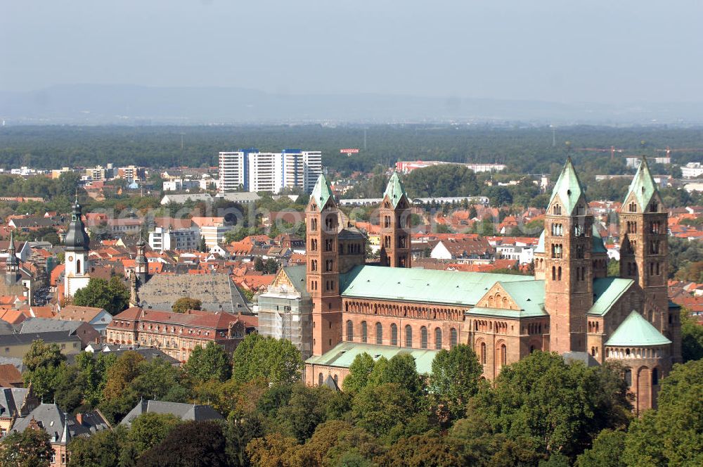 SPEYER from the bird's eye view: Der Kaiser- und Mariendom zu Speyer ist nach der Zerstörung der Abtei Cluny die größte noch erhaltene romanische Kirche der Welt und steht seit 1981 auf der UNESCO-Liste des Weltkulturerbes.Der salische Kaiser Konrad II. gründete um 1030 den Bau mit dem Ziel, die größte Kirche des Abendlandes zu bauen.Knapp 20 Jahre nach der Vollendung von Speyer I ließ Heinrich IV. den Dom zur Hälfte einreißen, um ihn noch größer wieder aufzubauen: Im Mittelschiff wurde die Decke abgetragen, der Bau wurde um fünf Meter erhöht. Statt der flachen Holzdecke entstand das größte Kreuzgratgewölbe im damaligen Reichsgebiet, auch der Wandaufriss erfuhr entscheidende Veränderungen. Im Ostteil wurde der Bau bis auf die Fundamente abgetragen und auf bis zu acht Metern starken Fundamenten neu gegründet. Es blieben lediglich die unteren Geschosse der Chorflankentürme, sowie Teile des Querhauses erhalten. Die Krypta von Speyer I blieb nahezu unberührt.Im Todesjahr Heinrichs IV., 1106, war der neue Dom fertiggestellt: Mit einer Länge von 444 römischen Fuß (134 Meter) und einer Breite von 111 römischen Fuß (43 Meter) war er eines der größten Bauwerke seiner Zeit. In der Länge übertraf den Speyerer Dom die Abteikirche von Cluny mit ihrer Vorkirche, der umbaute Raum jedoch ist beim Speyrer Dom mit über 40.000 Kubikmetern größer. Diese Veränderungen unter Heinrich IV. sind in der Forschung als Speyer II bekannt, wobei im heutigen Bau zwischen Bauteilen von Speyer I und Speyer II unterschieden wird.