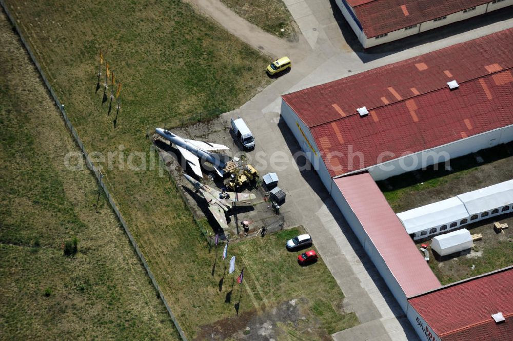 10.05.2011 from the bird's eye view: Kampfjet vom Typ Su-7 und MiG 23 auf dem Gelände des Gewerbezentrum Beelitz-Süd in Brandenburg. Die Su-7 stammt aus Großenhain und die MiG23 aus Jüterburg, welche gerade zu Restaurierungsarbeiten demontiert wird. A Su-7 and a MiG23 jet fighter at the Beelitz-South commercial area.