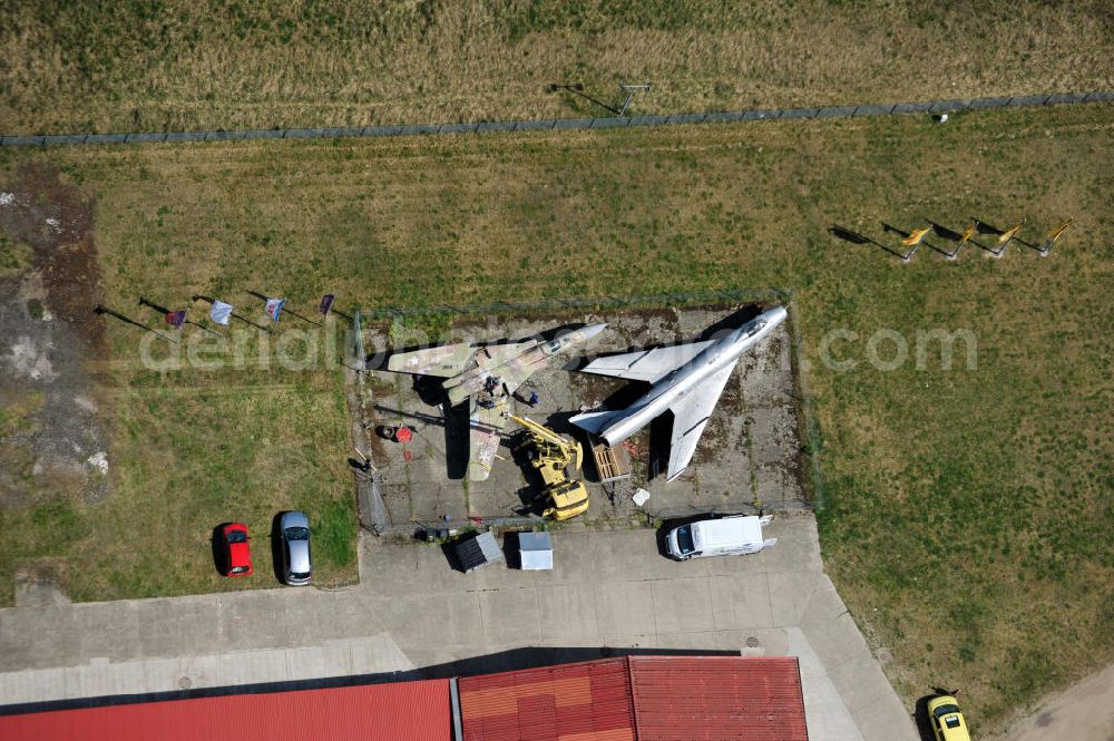 Aerial photograph 10.05.2011 - Kampfjet vom Typ Su-7 und MiG 23 auf dem Gelände des Gewerbezentrum Beelitz-Süd in Brandenburg. Die Su-7 stammt aus Großenhain und die MiG23 aus Jüterburg, welche gerade zu Restaurierungsarbeiten demontiert wird. A Su-7 and a MiG23 jet fighter at the Beelitz-South commercial area.