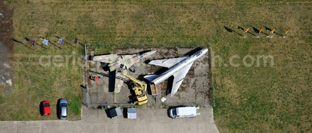 10.05.2011 from the bird's eye view: Kampfjet vom Typ Su-7 und MiG 23 auf dem Gelände des Gewerbezentrum Beelitz-Süd in Brandenburg. Die Su-7 stammt aus Großenhain und die MiG23 aus Jüterburg, welche gerade zu Restaurierungsarbeiten demontiert wird. A Su-7 and a MiG23 jet fighter at the Beelitz-South commercial area.