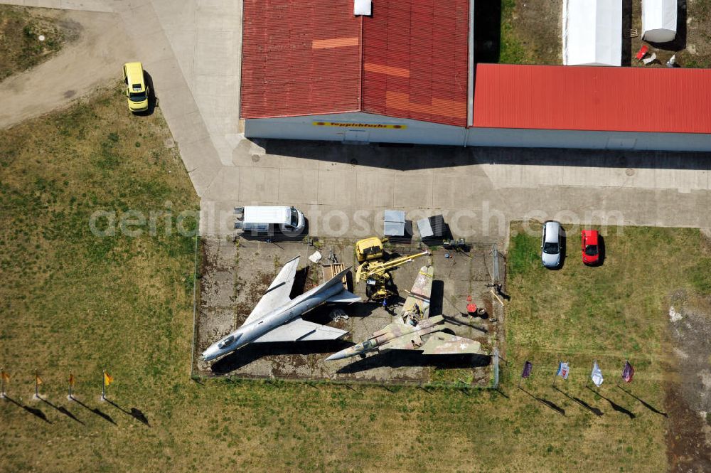 Aerial photograph 10.05.2011 - Kampfjet vom Typ Su-7 und MiG 23 auf dem Gelände des Gewerbezentrum Beelitz-Süd in Brandenburg. Die Su-7 stammt aus Großenhain und die MiG23 aus Jüterburg, welche gerade zu Restaurierungsarbeiten demontiert wird. A Su-7 and a MiG23 jet fighter at the Beelitz-South commercial area.