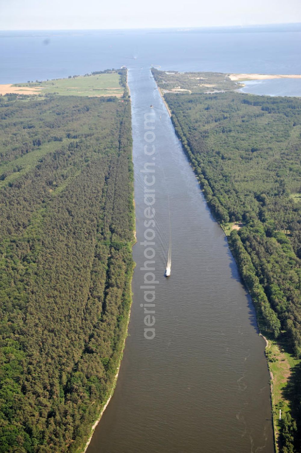 Aerial photograph Swinemünde ( Swinoujscie ) - Der Kanal Piastowski, übersetzt Piastenkanal, ist seit 1945 Name des 1875 bis 1880 als Kaiserfahrt erbauten Kanals, der die Swine (poln. Swina) südlich der Hafenstadt Swinoujscie (Swinemünde) mit dem Stettiner Haff verbindet. Die zwölf Kilometer lange Schifffahrtsstraße mit einer Wassertiefe von etwa zehn Metern umgeht den schwer befahrbaren östlichen Lauf der Swine. Channel Piastowski / Piastenkanal as Kaiserfahrt built south of Swinoujscie in Poland.