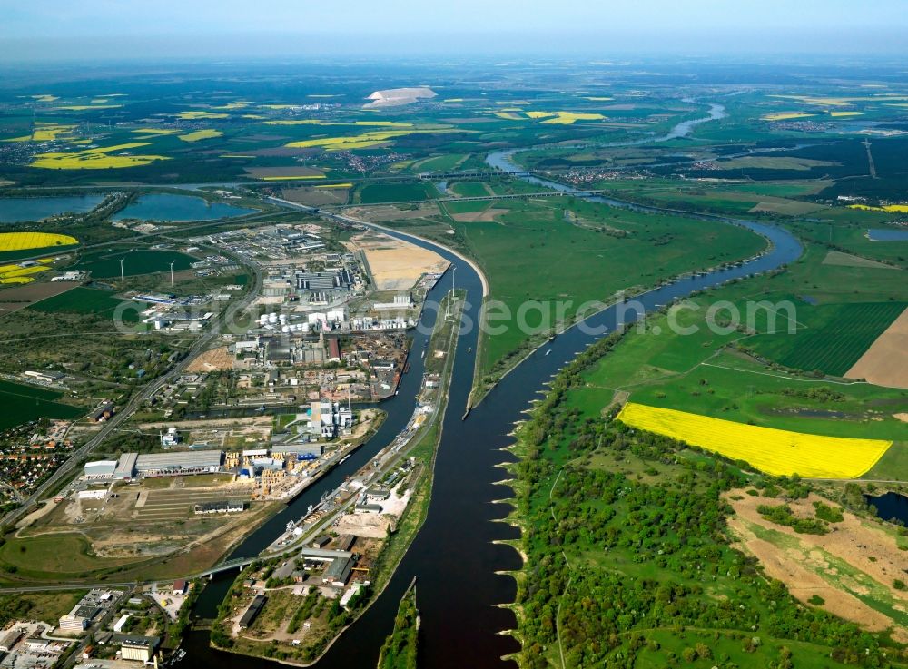 Aerial photograph Magdeburg - Kanalhafen (Canal Harbour) and Hansehafen (Hanseatic Harbour) on the river Elbe in Magdeburg in the state of Saxony-Anhalt. The two ports are part of four ports in the city that are used for handling cargo. The Steinkopf Island is surrounded by the river Elbe, the downstream Rothensee and the branch channel. Two wind energy facilities and several industrial and commercial buildings are located on the island