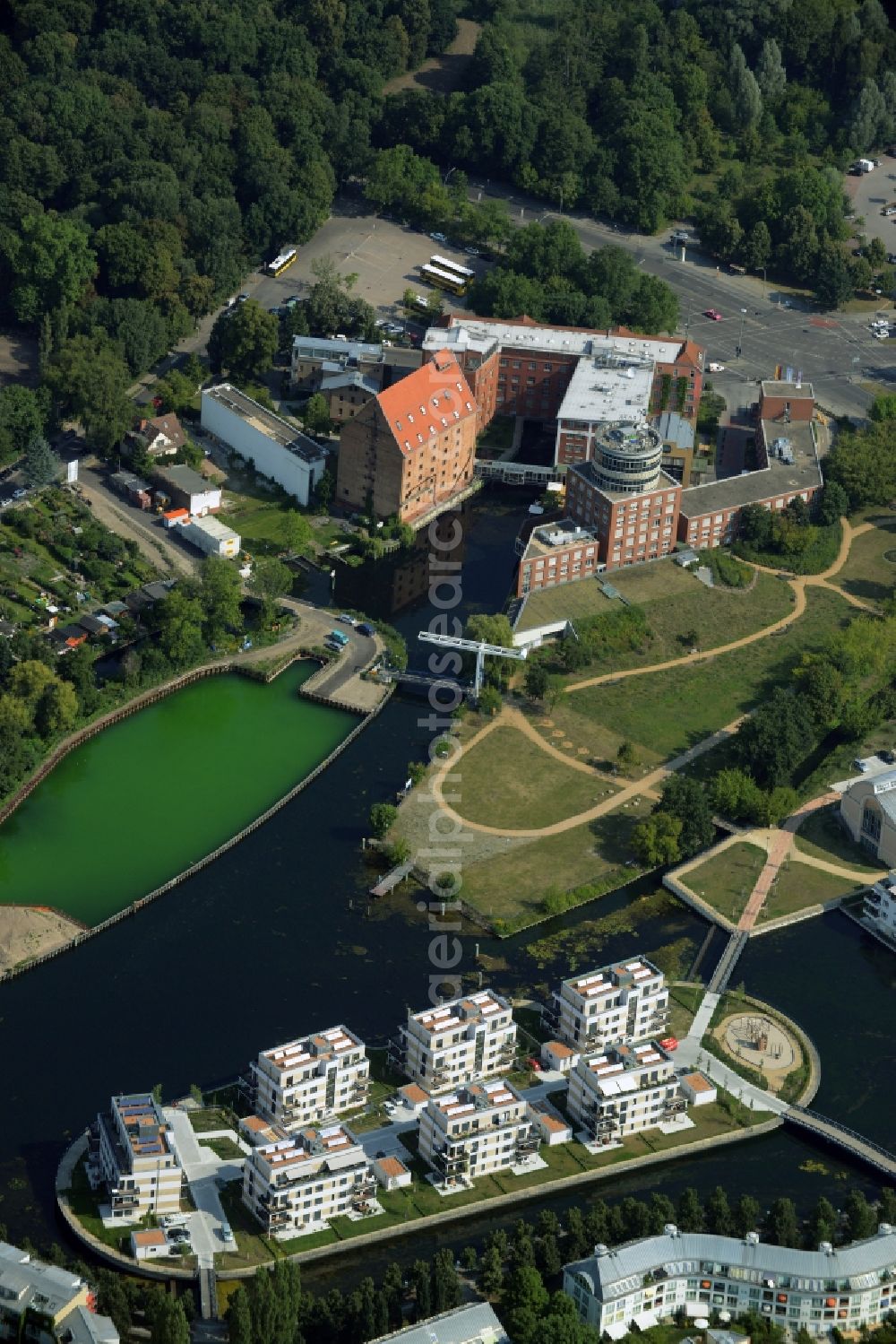 Berlin from the bird's eye view: History channel and riparian areas with housing areas of the Tegeler Fliess at the Tegeler See in Reinickendorf in Berlin in Germany. Also shown the Tegeler Insel and the construction area at the Humboldtinsel