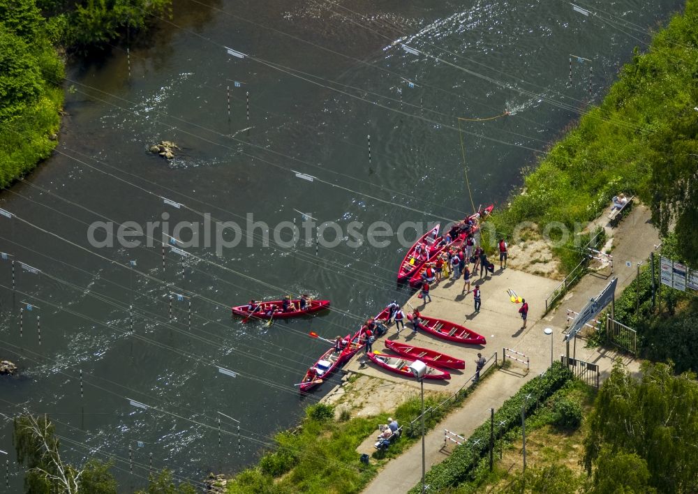 Schwerte from the bird's eye view: Canoes on the river Ruhr in Schwerte in the state of North Rhine-Westphalia. The river is a beloved region for canoeing. The distinct red paddle boats of Lenne-Ruhr-Canoe-Tours are located on the water