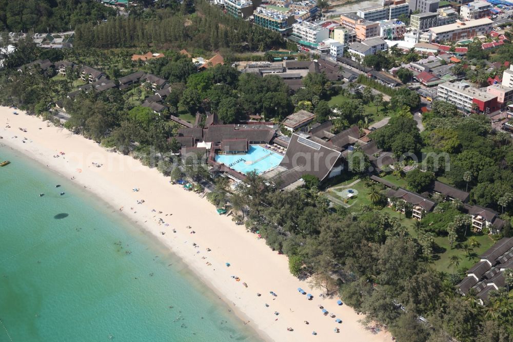 Karon from the bird's eye view: The Kata Beach in front of the city Karon on the island of Phuket in Thailand is a sandy beach with a island in front. Between the beach and the town are hotels, sports facilities and green areas