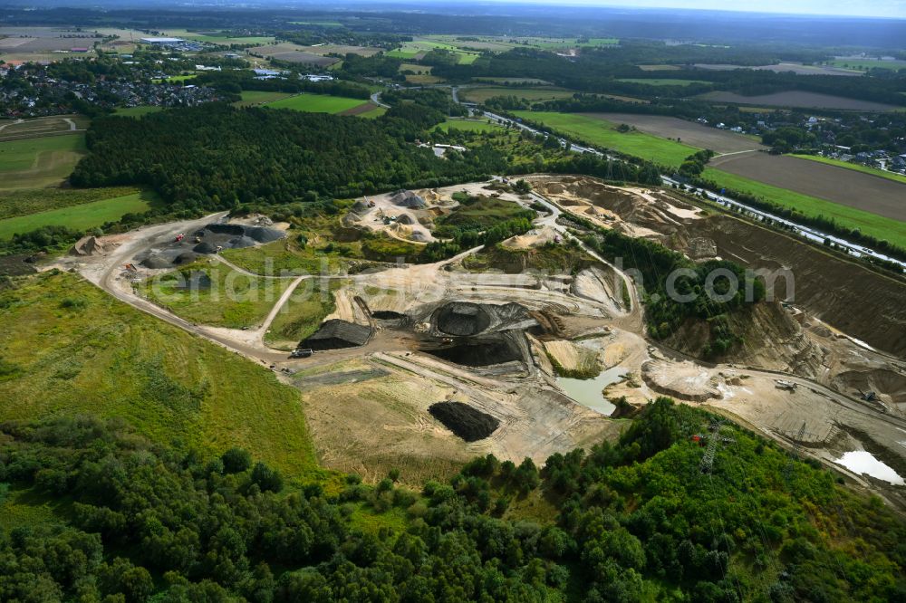 Dibbersen from the bird's eye view: Site and tailings area of the gravel mining on motorway BAB A1 in Dibbersen in the state Lower Saxony, Germany