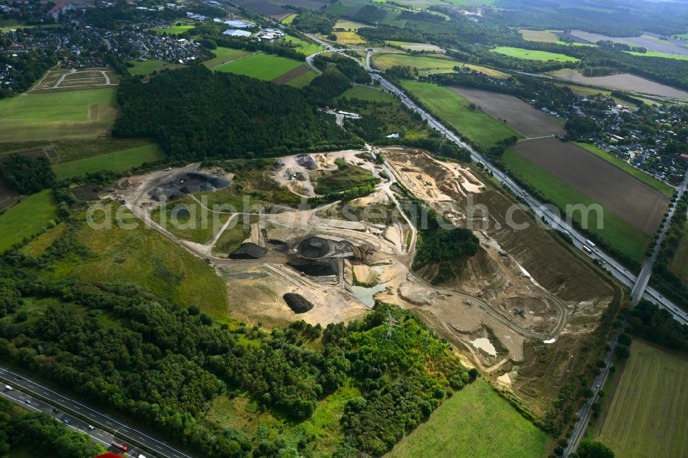 Dibbersen from the bird's eye view: Site and tailings area of the gravel mining on motorway BAB A1 in Dibbersen in the state Lower Saxony, Germany