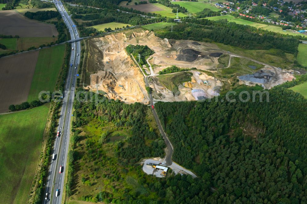 Dibbersen from the bird's eye view: Site and tailings area of the gravel mining on motorway BAB A1 in Dibbersen in the state Lower Saxony, Germany