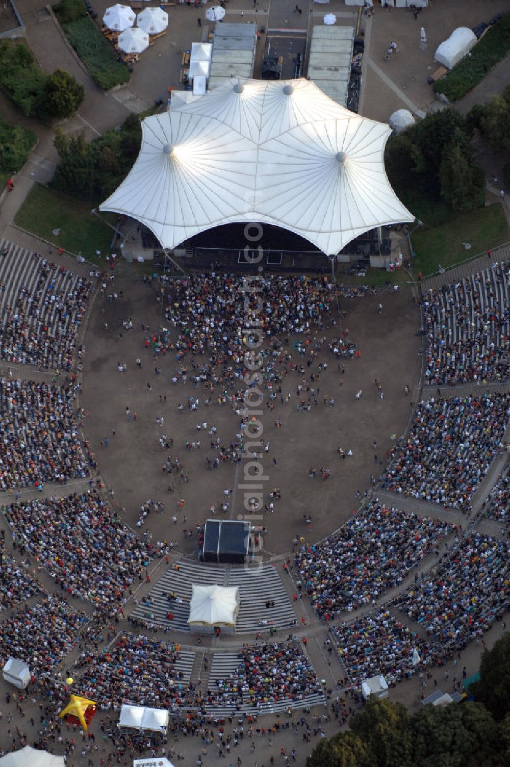 Berlin from above - Blick auf die Kindl-Bühne (auch Parkbühne Wuhlheide genannt) eine Viertelstunde nach Einlassbeginn zum Abschluss-Konzert von Peter Fox featuring Cold Steel. Einlass war ab 17.00 Uhr, Konzertbeginn um 19.30 Uhr. Einige Konzertbesucher haben es sich während der langen Wartezeit auf Matten bequem gemacht. Das Konzert war ausverkauft. Kontakt Kindl-Bühne Wuhlheide: Tel. +49(0)30 8575810, Email: info@wuhlheide.de