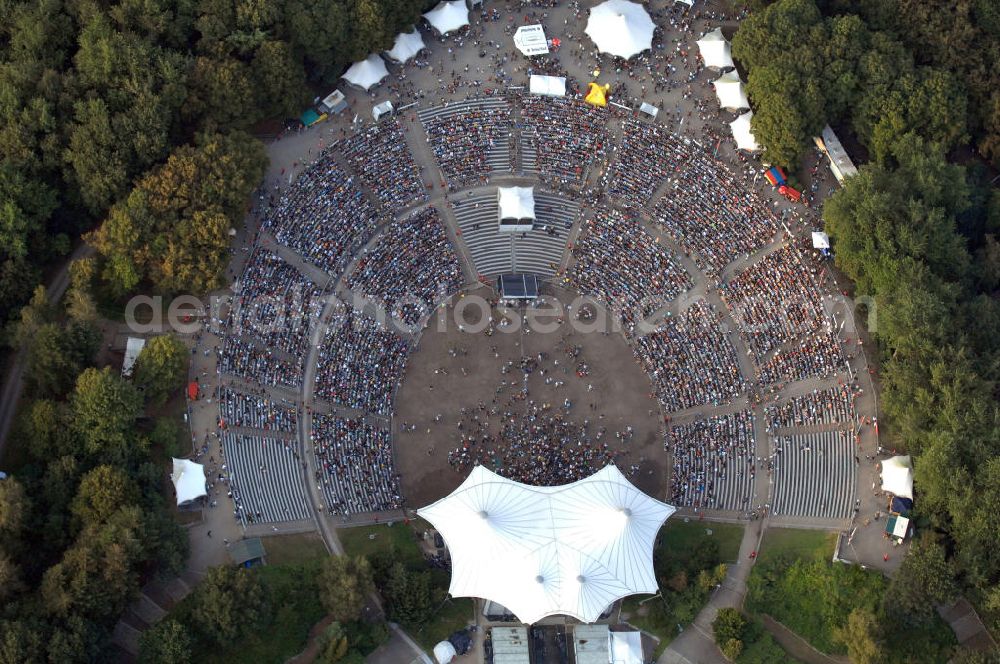 Berlin from above - Blick auf die Kindl-Bühne (auch Parkbühne Wuhlheide genannt) eine Viertelstunde nach Einlassbeginn zum Abschluss-Konzert von Peter Fox featuring Cold Steel. Einlass war ab 17.00 Uhr, Konzertbeginn um 19.30 Uhr. Einige Konzertbesucher haben es sich während der langen Wartezeit auf Matten bequem gemacht. Das Konzert war ausverkauft. Kontakt Kindl-Bühne Wuhlheide: Tel. +49(0)30 8575810, Email: info@wuhlheide.de