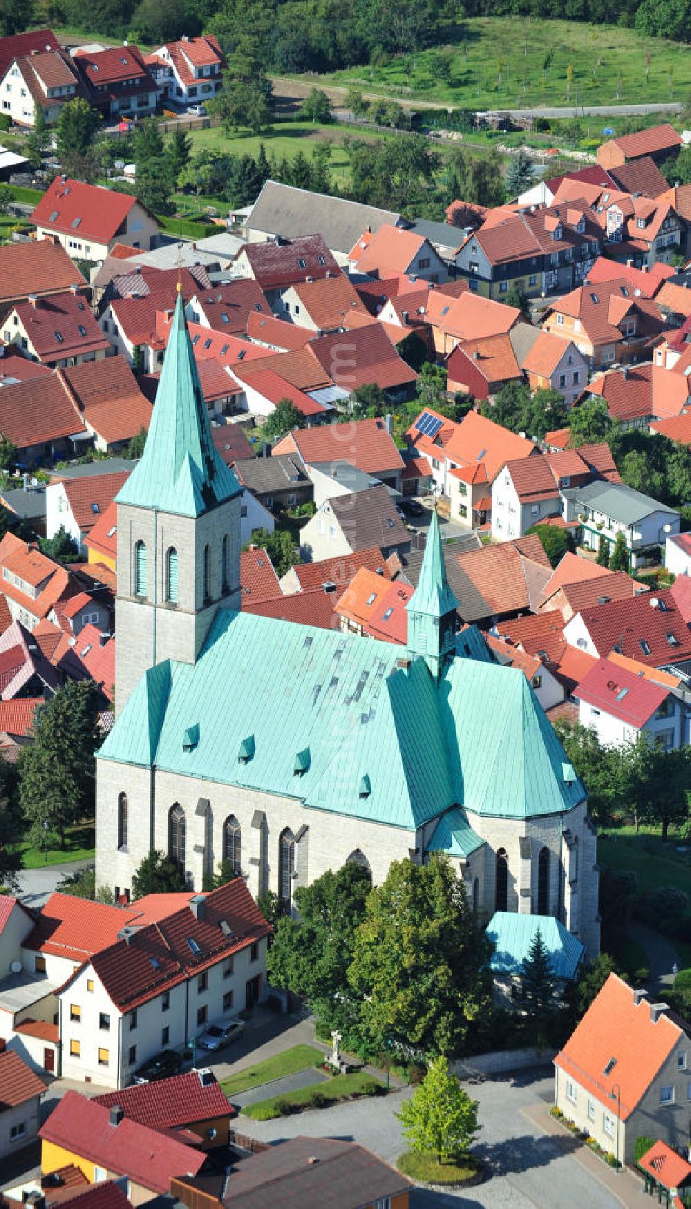 Effelder from the bird's eye view: Die Kirche St. Alban der Gemeinde Effelder im Landkreis Eichsfeld in Thüringen mit ihrem für die Gegend charakteristischen Kupferdach wurde 1892 vom Franziskaner Paschalis Gratze erbaut. Ihr 56 Meter hoher Turm ragt als Landmarke weit über das Umfeld der Gemeinde hinaus. Die römisch - katholische dreischiffige Hallenkirche im neugotischen Stil wird aufgrund ihres Gesamteindrucks auch als Eichsfelder Dom bezeichnet. Church St. Alban of municipality Effelder in borough Eichsfeld in Thuringia with its characteristic copper roof was built by Franciscan Paschalis Gratze in 1892. Its 56 metres high tower is a landmark. The Roman Catholic three-aisled hall church in neo-Gothic style is also called Eichsfelder Dom.