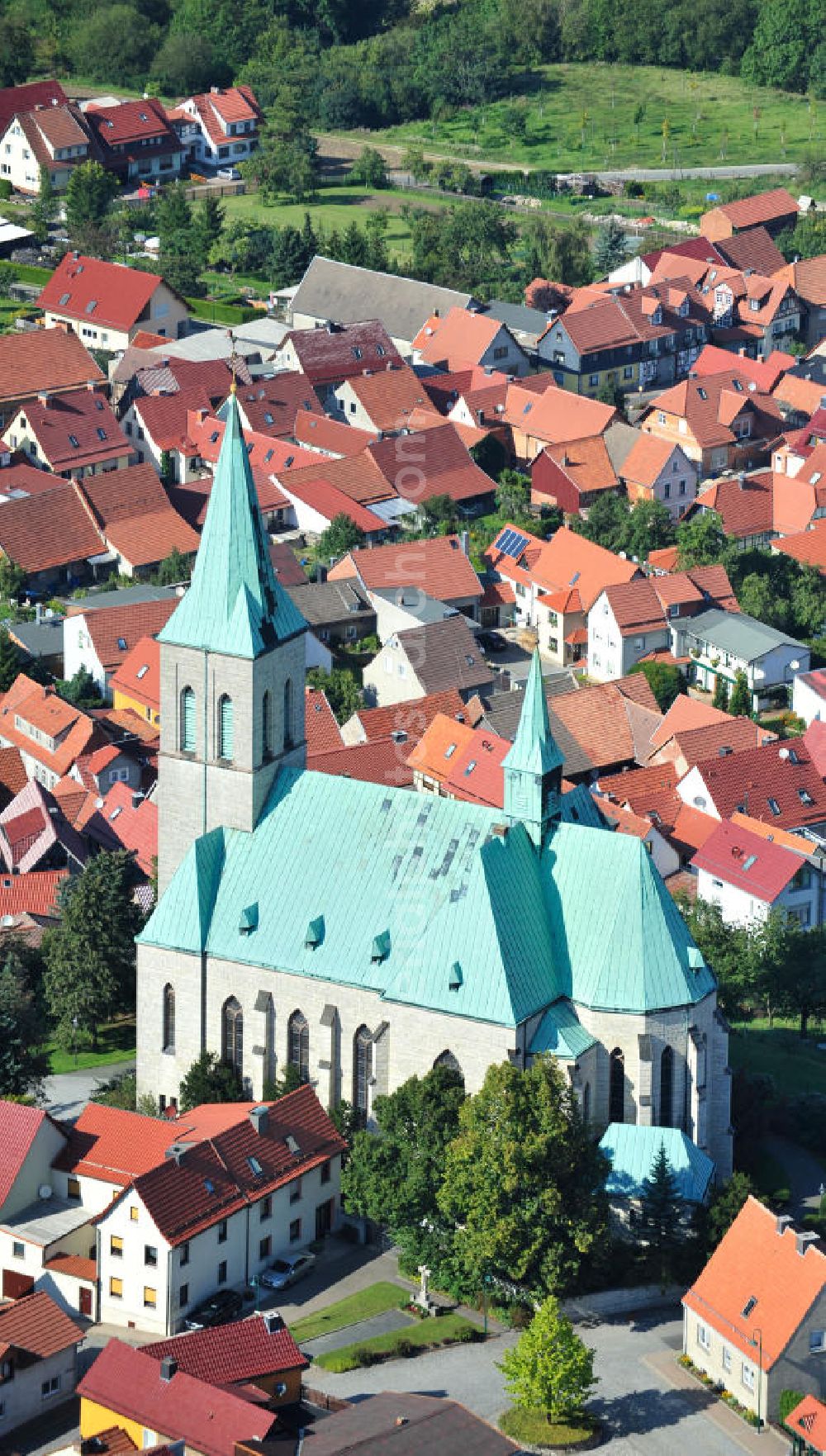 Aerial image Effelder - Die Kirche St. Alban der Gemeinde Effelder im Landkreis Eichsfeld in Thüringen mit ihrem für die Gegend charakteristischen Kupferdach wurde 1892 vom Franziskaner Paschalis Gratze erbaut. Ihr 56 Meter hoher Turm ragt als Landmarke weit über das Umfeld der Gemeinde hinaus. Die römisch - katholische dreischiffige Hallenkirche im neugotischen Stil wird aufgrund ihres Gesamteindrucks auch als Eichsfelder Dom bezeichnet. Church St. Alban of municipality Effelder in borough Eichsfeld in Thuringia with its characteristic copper roof was built by Franciscan Paschalis Gratze in 1892. Its 56 metres high tower is a landmark. The Roman Catholic three-aisled hall church in neo-Gothic style is also called Eichsfelder Dom.