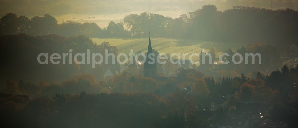 Witten from above - Church building of the protestant church Bommern in autumnal fog in Witten in the state of North Rhine-Westphalia. The church is located amidst autumnal colourful trees in a residential area