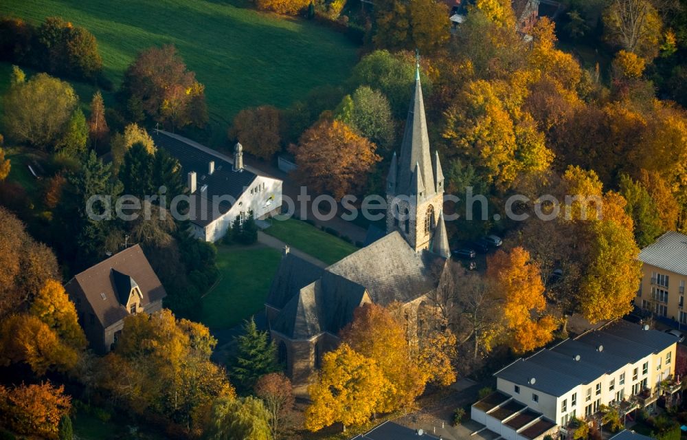 Aerial photograph Witten - Church building of the protestant church Bommern in Witten in the state of North Rhine-Westphalia. The church is located amidst autumnal colourful trees in a residential area