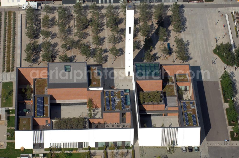 Aerial photograph München - Das Kirchenzentrum Riem ist die räumliche wie auch geistige Mitte der 556 Hektar großen Messestadt Riem auf dem ehemaligen Flughafenbgelände ist das Kirchenzentrum der beiden großen christlichen Konfessionen am Platz der Menschenrechte. Die Pfarrerswohnung, die sich mit insgesamt fünf Zimmern auf zwei Ebenen über den Gemeinderäumen für Mutter und Kind erstreckt, orientiert sich nicht nur nach Süden auf einen großen Innenhof mit Bäumen. Vom ersten Obergeschoss des Pfarrhauses führt auch ein langer Holzsteg zu zwei Dachterrassen, die sich für Wolfgang Gerbere wie für kirchliche Zwecke nutzen lassen. Allein schon dieser Bereich des Kirchenzentrums vermittelt die städtebauliche Grundidee von Architekt Florian Nagler: Die ganze Anlage richtet sich nach innen auf vier unterschiedlich dimensionierte Höfe, die von hohen Wänden mit einem präzisen Fugenbild geschützt sind. Konsequenterweise hat Nagler mehrere Flachdächer für Veranstaltungen im Freien aktiviert.