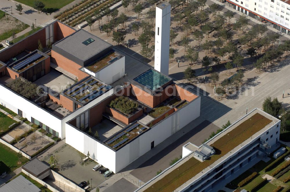 Aerial image München - Das Kirchenzentrum Riem ist die räumliche wie auch geistige Mitte der 556 Hektar großen Messestadt Riem auf dem ehemaligen Flughafenbgelände ist das Kirchenzentrum der beiden großen christlichen Konfessionen am Platz der Menschenrechte. Die Pfarrerswohnung, die sich mit insgesamt fünf Zimmern auf zwei Ebenen über den Gemeinderäumen für Mutter und Kind erstreckt, orientiert sich nicht nur nach Süden auf einen großen Innenhof mit Bäumen. Vom ersten Obergeschoss des Pfarrhauses führt auch ein langer Holzsteg zu zwei Dachterrassen, die sich für Wolfgang Gerbere wie für kirchliche Zwecke nutzen lassen. Allein schon dieser Bereich des Kirchenzentrums vermittelt die städtebauliche Grundidee von Architekt Florian Nagler: Die ganze Anlage richtet sich nach innen auf vier unterschiedlich dimensionierte Höfe, die von hohen Wänden mit einem präzisen Fugenbild geschützt sind. Konsequenterweise hat Nagler mehrere Flachdächer für Veranstaltungen im Freien aktiviert.