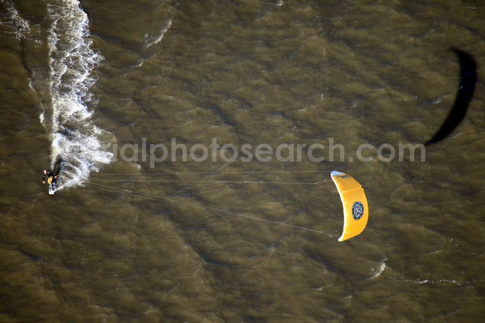 Cuxhaven from above - Kite Surfer in the Hamburg Wadden Sea in front of Cuxhaven in the state of Lower Saxony. The National Park is located in the North Sea at the mouth of the river Elbe. The surfer uses a large power kite to move with wind power