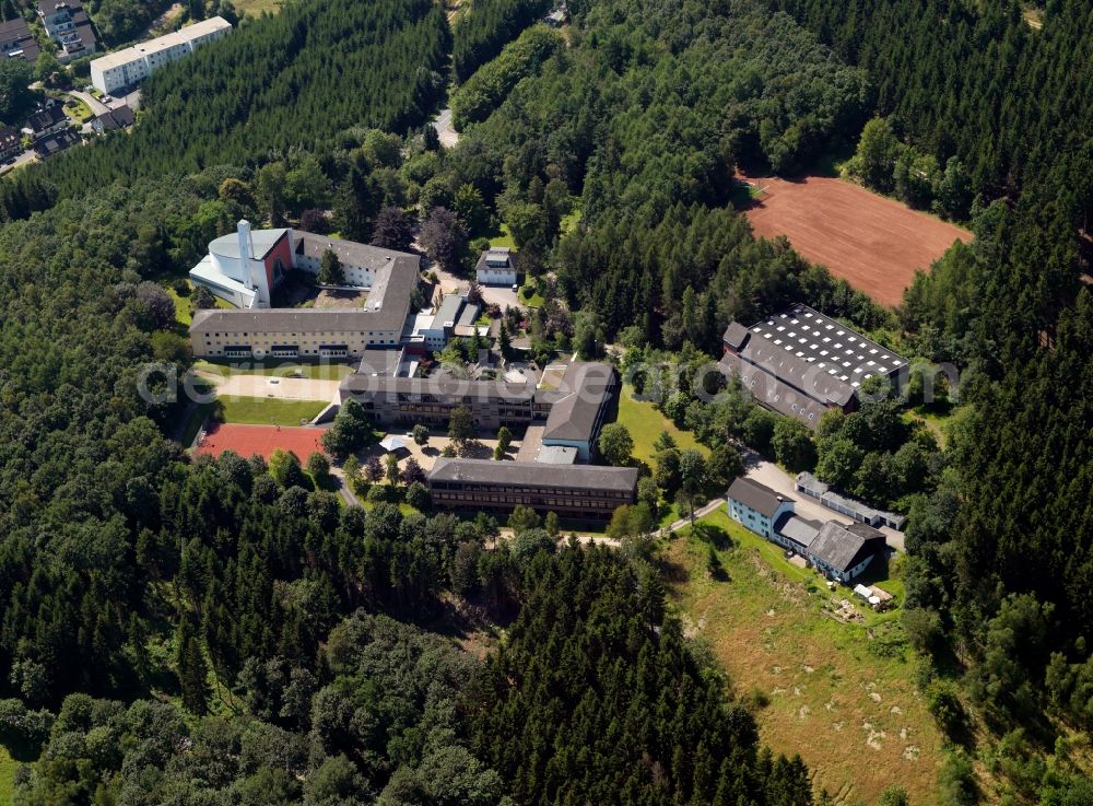 Aerial image Lennestadt - Monastery and secondary school Maria Koenigin (Queen Mary) near the Altenhundem part of Lennestadt in the state of North Rhine-Westphalia. The church was opened in 1959. Its white tower is widely visible. The school was opened in 1967 and is located in the long darker buildings between trees and forest on a hill