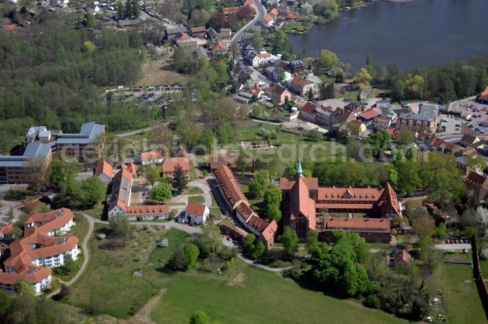 LEHNIN from above - Das Kloster Lehnin in der gleichnamigen Gemeinde südwestlich von Potsdam ist eine ehemalige Zisterzienserabtei. 1180 gegründet und im Zuge der Reformation 1542 säkularisiert, beherbergt es seit 1911 das Luise-Henrietten-Stift. Das Kloster liegt im Zentrum der Hochfläche Zauche in wald- und wasserreicher Umgebung rund 700 Meter vom Klostersee entfernt. Das Kloster spielte im Hochmittelalter eine wichtige Rolle beim Landesausbau der jungen Mark Brandenburg unter deren ersten Markgrafen aus dem Haus der Askanier. Neben seiner historischen kommt dem Kloster auch eine große kulturelle Bedeutung zu: Seine Kirche zählt zu den wichtigsten romanisch-gotischen Backsteinbauten in Brandenburg. Deren Rekonstruktion in den Jahren von 1871 bis 1877 gilt als frühe Glanzleistung der modernen Denkmalpflege. Das heutige Lehniner Stift sieht sich mit seinen pflegerischen, medizinischen und ausbildenden diakonischen Einrichtungen in der klösterlichen Tradition und versteht sich als Schaufenster der Evangelischen Kirche.