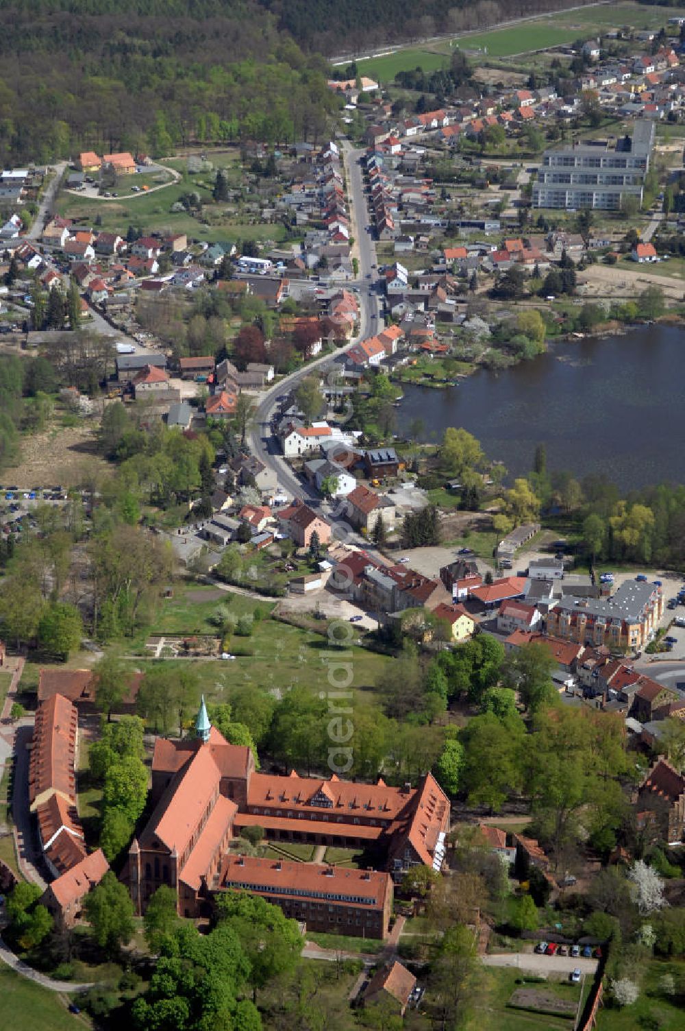 Aerial image LEHNIN - Das Kloster Lehnin in der gleichnamigen Gemeinde südwestlich von Potsdam ist eine ehemalige Zisterzienserabtei. 1180 gegründet und im Zuge der Reformation 1542 säkularisiert, beherbergt es seit 1911 das Luise-Henrietten-Stift. Das Kloster liegt im Zentrum der Hochfläche Zauche in wald- und wasserreicher Umgebung rund 700 Meter vom Klostersee entfernt. Das Kloster spielte im Hochmittelalter eine wichtige Rolle beim Landesausbau der jungen Mark Brandenburg unter deren ersten Markgrafen aus dem Haus der Askanier. Neben seiner historischen kommt dem Kloster auch eine große kulturelle Bedeutung zu: Seine Kirche zählt zu den wichtigsten romanisch-gotischen Backsteinbauten in Brandenburg. Deren Rekonstruktion in den Jahren von 1871 bis 1877 gilt als frühe Glanzleistung der modernen Denkmalpflege. Das heutige Lehniner Stift sieht sich mit seinen pflegerischen, medizinischen und ausbildenden diakonischen Einrichtungen in der klösterlichen Tradition und versteht sich als Schaufenster der Evangelischen Kirche.