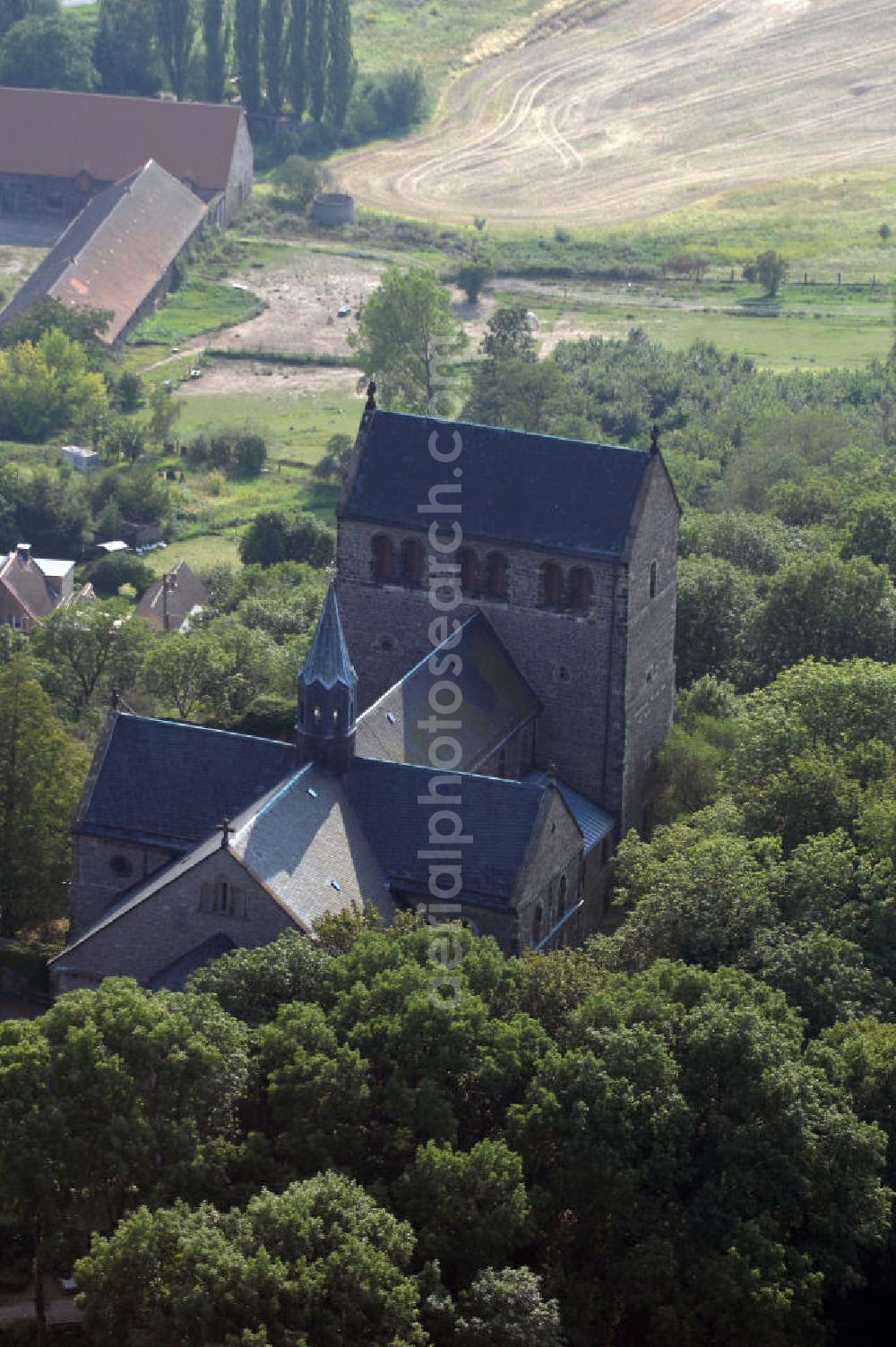 Petersberg from the bird's eye view: Strasse der Romanik: In den Jahren 1124 liegt der Baubeginn der Klosterkirche des von Graf Dedo von Wettin gegründeten Augustiner-Chorherrenstifts. Ein wesentliches Merkmal ist die eingeengte Bauweise, was natürlich auf den spärlichen Platz des Berges zurückzuführen ist. Die durch den damaligen Brand zerstörten Bronzeplatten der Wettiner, sind heute als Sandsteinnachbildungen zu sehen.