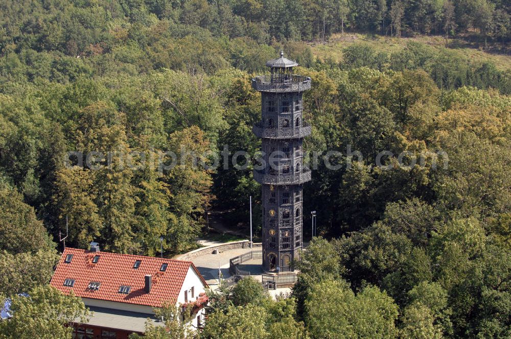 Aerial photograph Löbau - Der König-Friedrich-August-Turm auf dem Löbauer Berg im sächsischen Löbau ist der einzige noch erhaltene gusseiserne Aussichtsturm in Europa und wahrscheinlich der älteste gusseiserne Turm überhaupt. Er wurde 1854 aus Gusseisen errichtet, weist eine Höhe von 28 Metern und einen Durchmesser von vier Metern auf, hat eine achteckige Form und enthält drei außenliegende Galerien in 12, 18 und 24 Meter Höhe. Die innenliegende Wendeltreppe hat 120 Stufen. Auf der Aussichtsplattform befindet man sich insgesamt in einer Höhe von 28 Metern. Vom Turm aus kann man bis zum Zittauer Gebirge und über weite Teile der Landschaft der Oberlausitz blicken. Der nach dem sächsischen König Friedrich August II. benannte Turm steht mittlerweile als technisches Denkmal unter Denkmalschutz und ist ein beliebtes, weithin bekanntes Ausflugsziel.