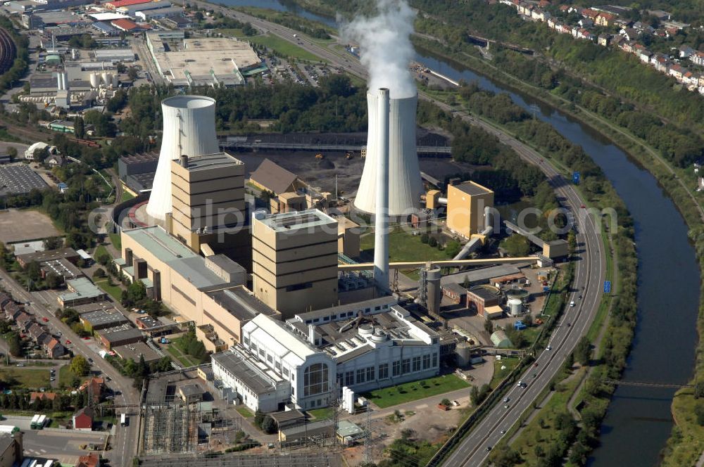 Aerial photograph Völklingen - Das Steinkohlekraftwerk Fenne bei Völklingen im Saarland bildet einen bedeutenden Teil der Fernwärmeschiene Saar, einem der größten deutschen Fernwärme-Verbundsysteme erstreckt über das ganze Saarland. Das erste Kraftwerk an diesem Standort wurde 1923 errichtet und später um weitere Maschinen und Kraftwerksblöcke erweitert. Neben Fernwärme liefert Fenne auch Strom und Prozessdampf. Betreiber der Anlage ist die Evonik New Energies GmbH und das Tochterunternehmen Steag GmbH. Hard coal-fired power station Fenne near Völklingen at state Saarland. First power station here was built in 1923, followed by further machines and extension buildings. Fenne delivers district heating, electricity and processual steam. Operators are Evonik New Energies GmbH and subsidiary Steag GmbH.