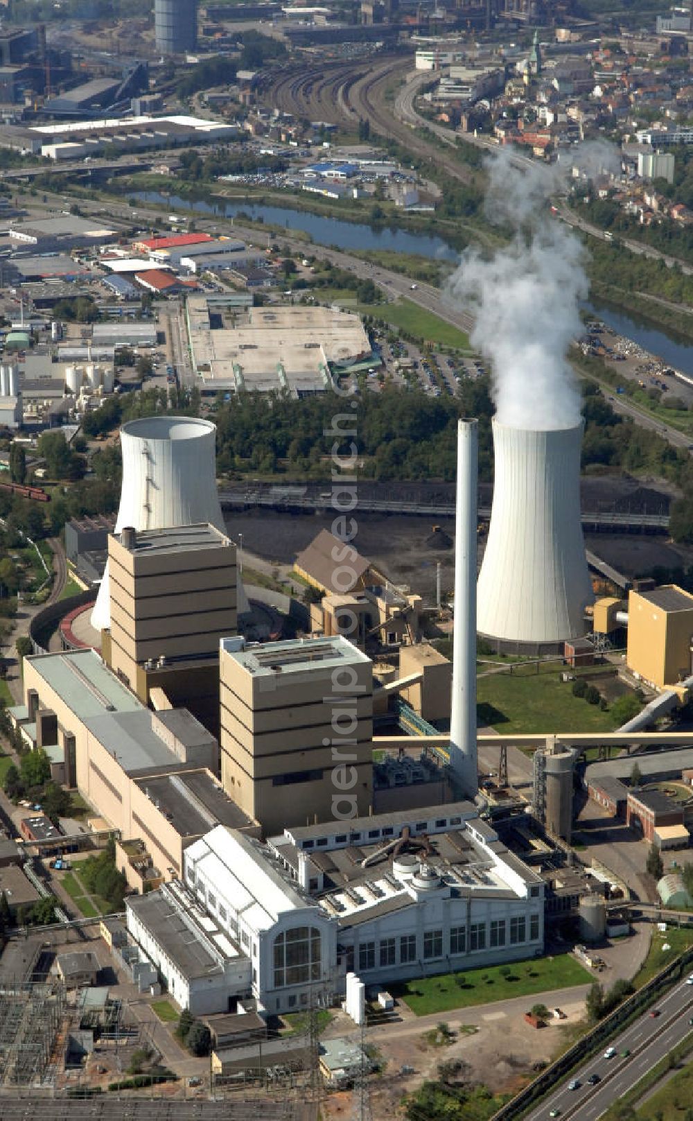 Völklingen from the bird's eye view: Das Steinkohlekraftwerk Fenne bei Völklingen im Saarland bildet einen bedeutenden Teil der Fernwärmeschiene Saar, einem der größten deutschen Fernwärme-Verbundsysteme erstreckt über das ganze Saarland. Das erste Kraftwerk an diesem Standort wurde 1923 errichtet und später um weitere Maschinen und Kraftwerksblöcke erweitert. Neben Fernwärme liefert Fenne auch Strom und Prozessdampf. Betreiber der Anlage ist die Evonik New Energies GmbH und das Tochterunternehmen Steag GmbH. Hard coal-fired power station Fenne near Völklingen at state Saarland. First power station here was built in 1923, followed by further machines and extension buildings. Fenne delivers district heating, electricity and processual steam. Operators are Evonik New Energies GmbH and subsidiary Steag GmbH.