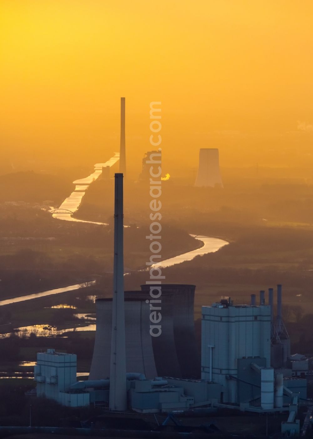 Werne from the bird's eye view: Power plants and exhaust towers of coal thermal power station Gersteinwerk of RWE Power in Werne in the state of North Rhine-Westphalia. The STEAG power plant of Bergkamen is visible in sunset in the background