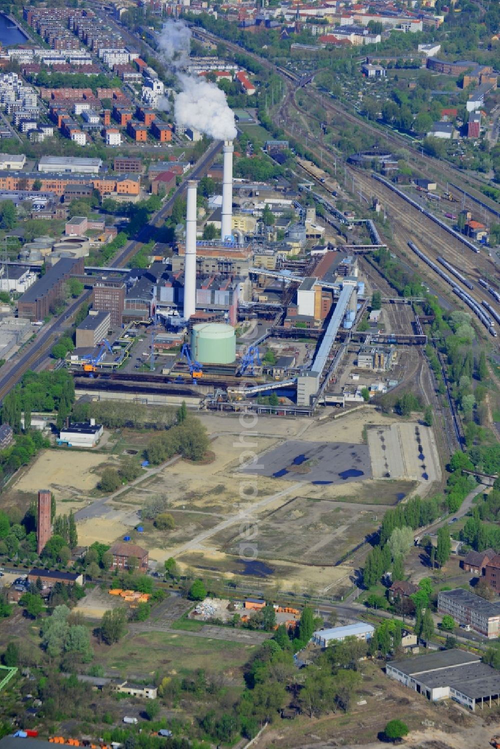 Aerial image Berlin - Coal power plants of the power plant Klingenberg in the Rummelsburg part of Berlin in Germany. The site stems from 1926 and is listed as a protected building. The technical components were renewed in the 1970s. Since then it is run by brown coal and produces heat for the district. It sits on the riverbank of the river Spree, surrounded by railway tracks, and belongs to Vattenfall GmbH