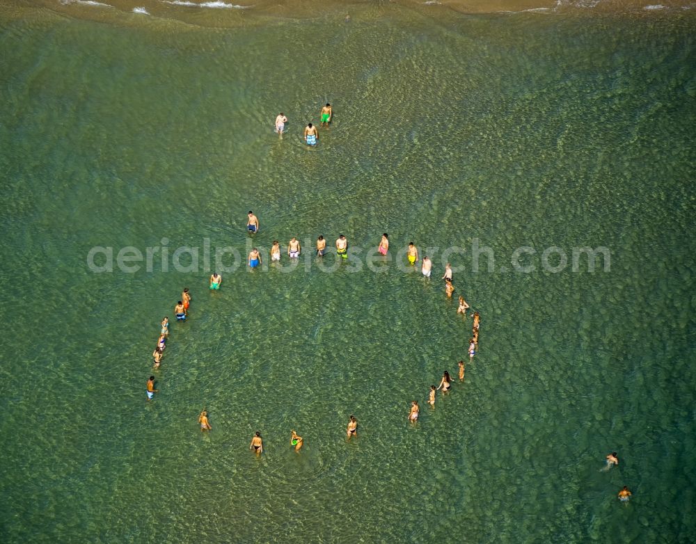 Le Barcarès from the bird's eye view: Circle of young people to play frisbee disc at the beach of Le Barcarès in France