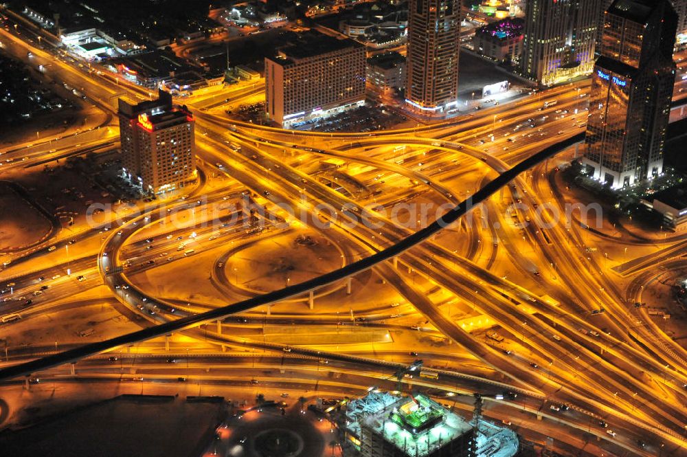 DUBAI / DUBAYY from above - Nachtluftbild vom Kreisverkehr an der D71 Financial Centre Road und der E 11 Sheikh Zayed Road. Moderne, teilweise sechsspurig beleuchtet ausgebaute Autobahnen und Schnellstraßen kennzeichnen die Infrastruktur aller Städte der Emirate. First Interchange on Sheikh Zayed Road, also known as Defense Roundabout.