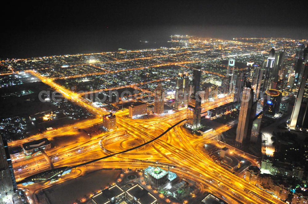 DUBAI / DUBAYY from above - Nachtluftbild vom Kreisverkehr an der D71 Financial Centre Road und der E 11 Sheikh Zayed Road. Moderne, teilweise sechsspurig beleuchtet ausgebaute Autobahnen und Schnellstraßen kennzeichnen die Infrastruktur aller Städte der Emirate. First Interchange on Sheikh Zayed Road, also known as Defense Roundabout.